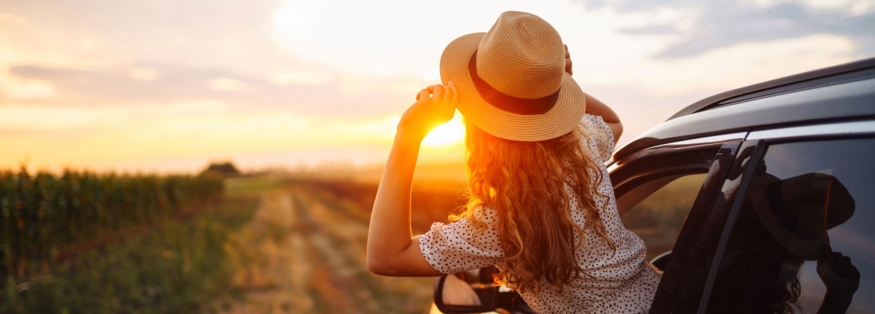 Ontspannen gelukkige vrouw op zomervakantie leunend uit autoraam